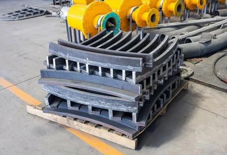 Stacked vertical roller mill nozzle ring segments with separate deflector vanes on wooden pallet, cement plant spare parts Stacked vertical roller mill nozzle ring segments with separate deflector vanes on wooden pallet, cement plant spare parts